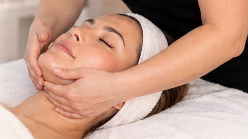 Therapist holding a client's jaw in both hands during a facial lifting massage